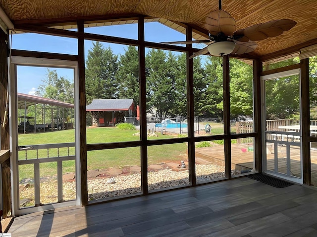 unfurnished sunroom featuring a ceiling fan