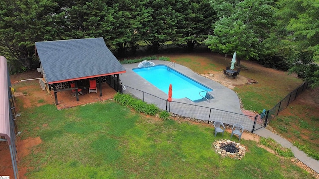 view of pool featuring a fenced backyard, a fenced in pool, a patio area, a lawn, and a fire pit