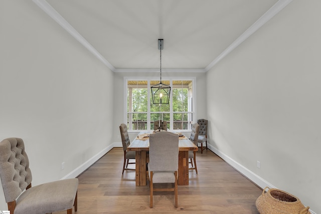 dining space with crown molding, baseboards, and wood finished floors