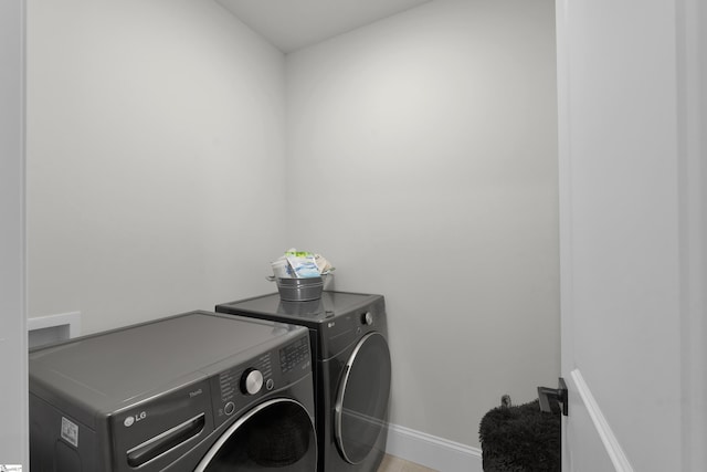 laundry area with separate washer and dryer, laundry area, and baseboards