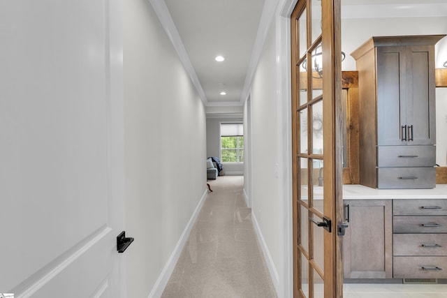 corridor with light colored carpet, recessed lighting, baseboards, visible vents, and ornamental molding