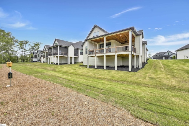 back of house with a yard, ceiling fan, a residential view, and a sunroom