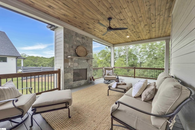 sunroom featuring a ceiling fan and an outdoor living space with a fireplace