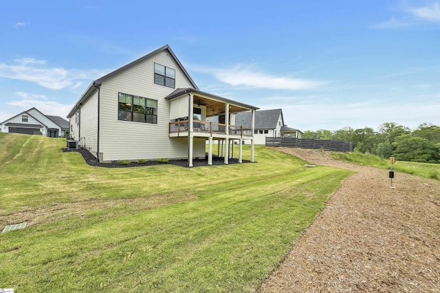 rear view of property featuring a lawn, central AC unit, ceiling fan, and a deck