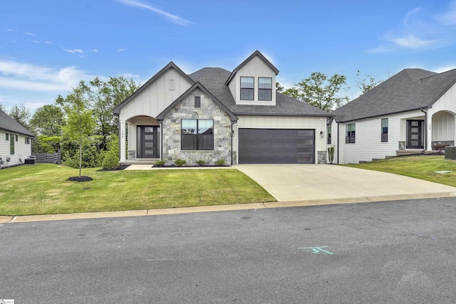 view of front of house with a front lawn, stone siding, a garage, board and batten siding, and driveway
