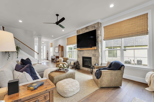 living area featuring ornamental molding, a ceiling fan, wood finished floors, and stairway