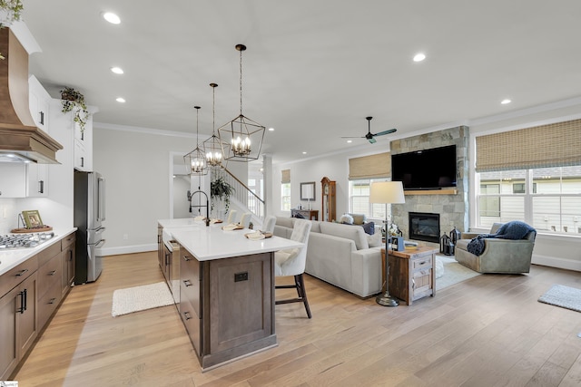 kitchen with baseboards, light countertops, ceiling fan, and ornamental molding