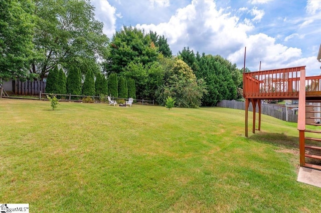 view of yard featuring fence and a deck