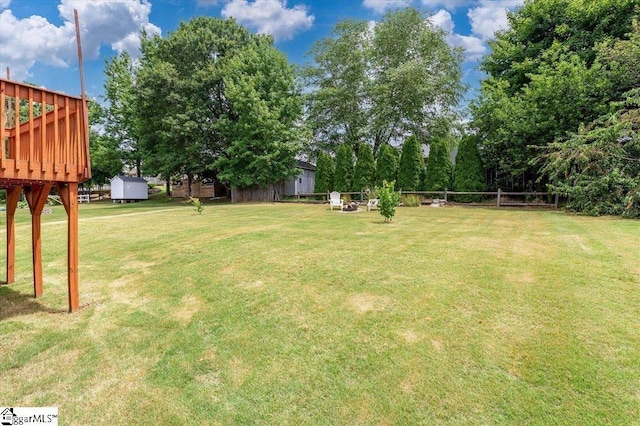view of yard featuring fence and a deck