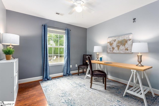 office with baseboards, ceiling fan, visible vents, and wood finished floors