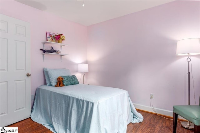 bedroom with baseboards and wood finished floors