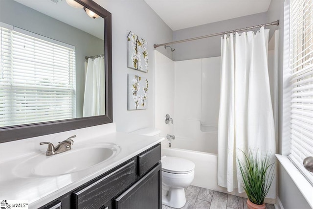 full bathroom featuring toilet, shower / bath combination with curtain, wood finished floors, and vanity