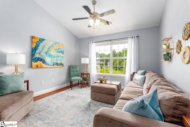 living room with baseboards, ceiling fan, wood finished floors, and vaulted ceiling