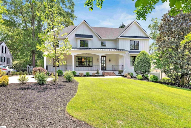 modern farmhouse style home with a front yard, a standing seam roof, a shingled roof, metal roof, and a porch
