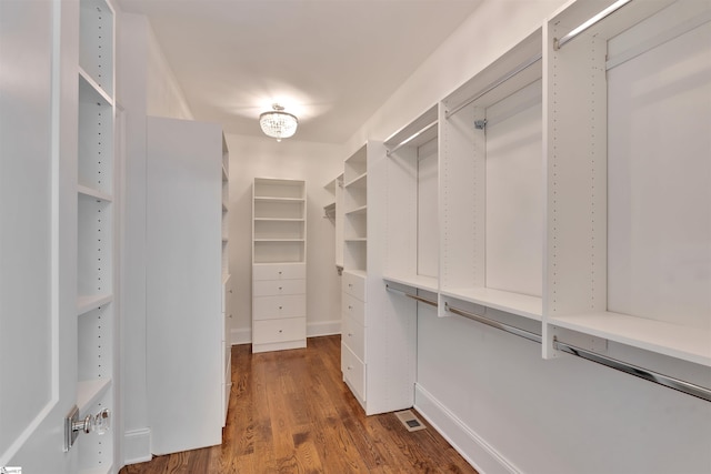 walk in closet with dark wood-style flooring and visible vents