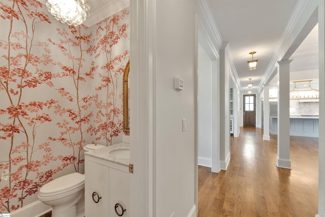 bathroom with vanity, ornamental molding, wood finished floors, and toilet