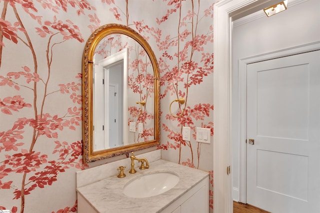 bathroom with vanity and wallpapered walls