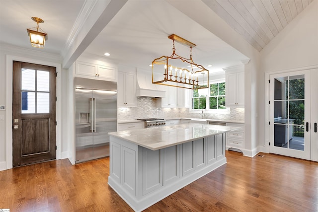 kitchen featuring backsplash, white cabinetry, built in fridge, and a kitchen island