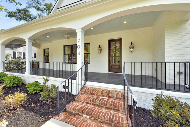 view of exterior entry featuring a porch and brick siding