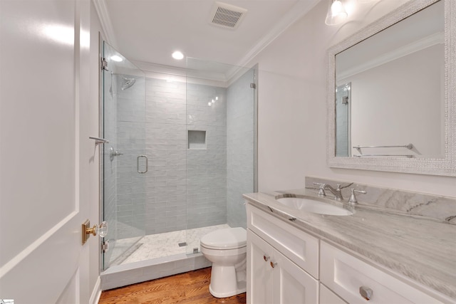 full bath with visible vents, crown molding, a shower stall, wood finished floors, and toilet