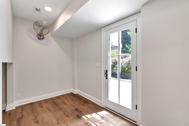 doorway featuring visible vents, baseboards, and wood finished floors