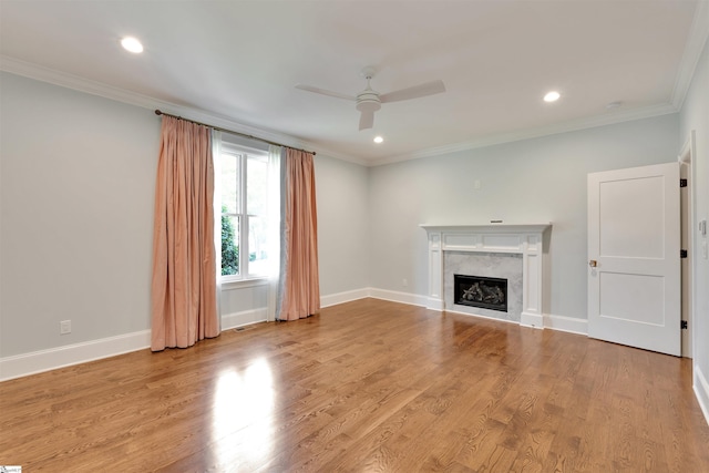 unfurnished living room featuring a ceiling fan, baseboards, ornamental molding, and a high end fireplace