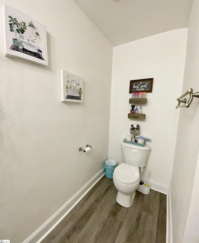 bathroom with baseboards, toilet, and wood finished floors