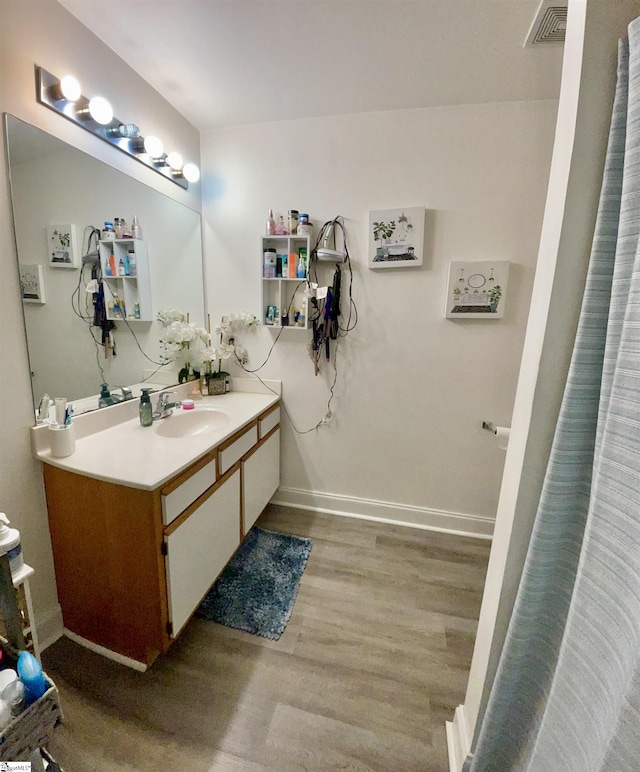 full bathroom featuring baseboards, visible vents, wood finished floors, and vanity