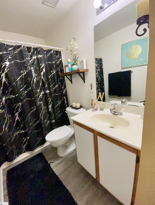 bathroom with vanity, toilet, curtained shower, and visible vents