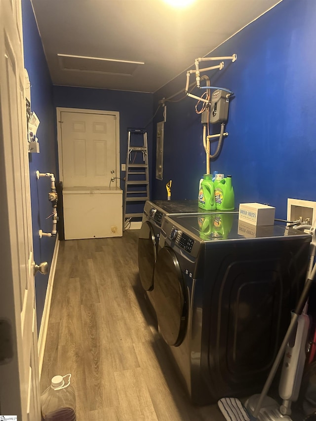 laundry area with laundry area, washer and clothes dryer, and wood finished floors