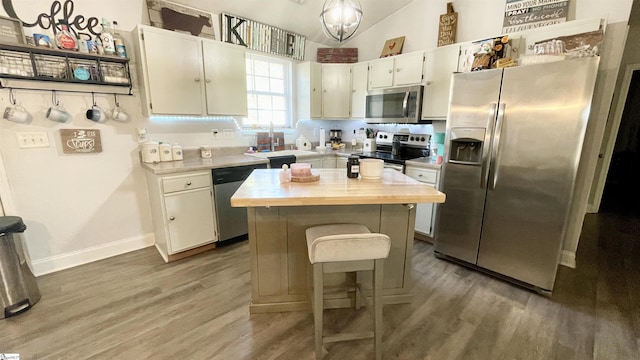 kitchen featuring a sink, light wood-style floors, wood counters, stainless steel appliances, and a kitchen island