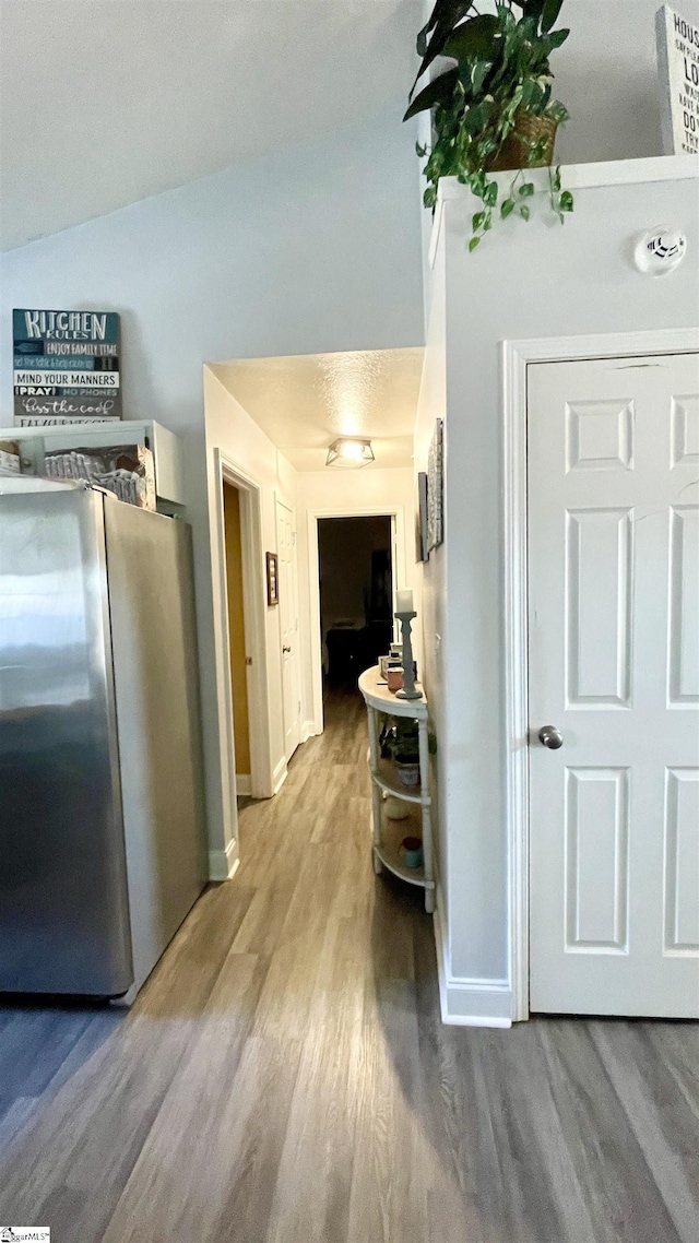 hallway featuring baseboards and wood finished floors
