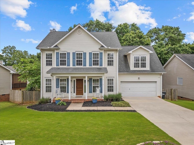 colonial inspired home with a porch, a garage, fence, and concrete driveway