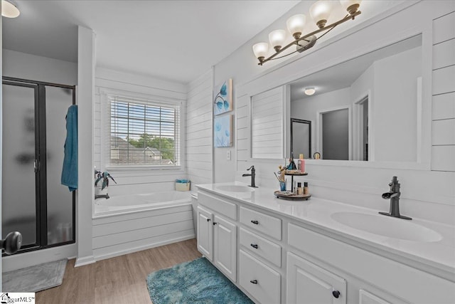 full bath featuring a sink, a shower stall, and wood finished floors