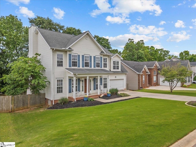 view of front of house featuring a front lawn, fence, a chimney, a porch, and driveway