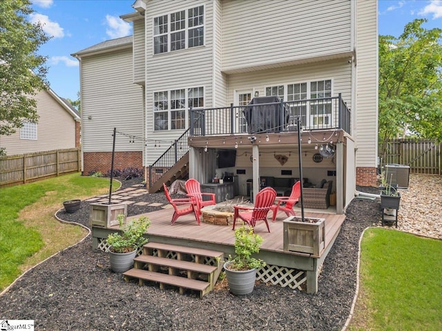 rear view of property featuring a yard, a wooden deck, stairs, and a fenced backyard