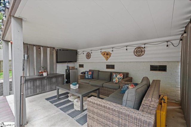 living area featuring concrete floors and brick wall