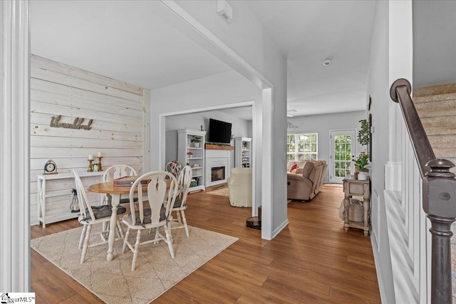 dining room featuring stairs, wood finished floors, and a fireplace