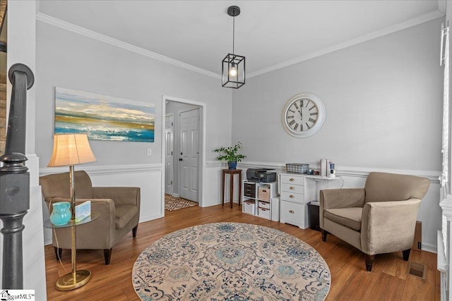 living area with ornamental molding and wood finished floors