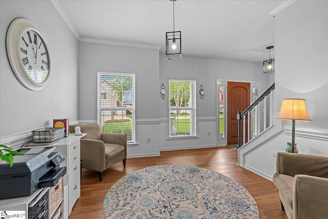 foyer entrance featuring crown molding, stairway, and wood finished floors