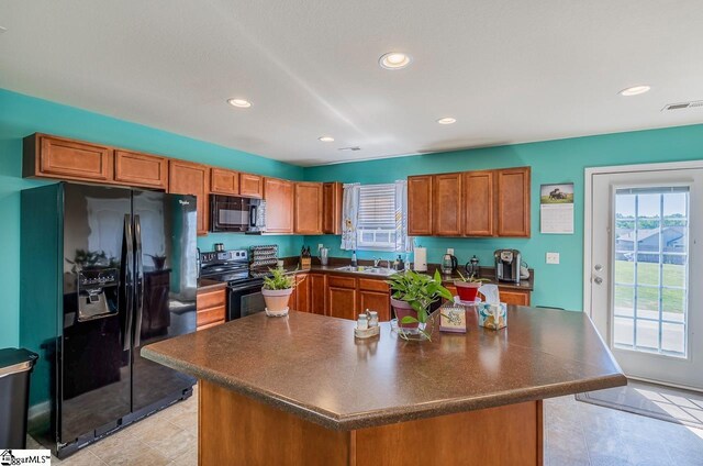 kitchen with visible vents, brown cabinetry, black appliances, and dark countertops