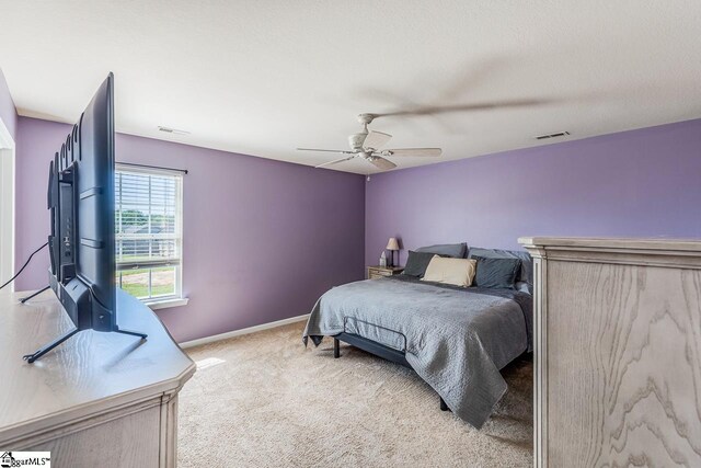 carpeted bedroom with baseboards, a ceiling fan, and visible vents