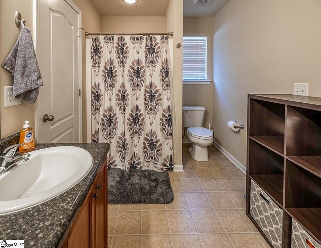 bathroom with a shower with curtain, vanity, tile patterned floors, baseboards, and toilet