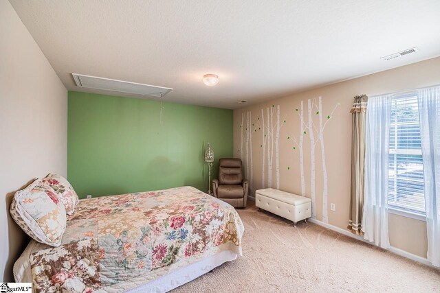 carpeted bedroom with baseboards, attic access, and visible vents