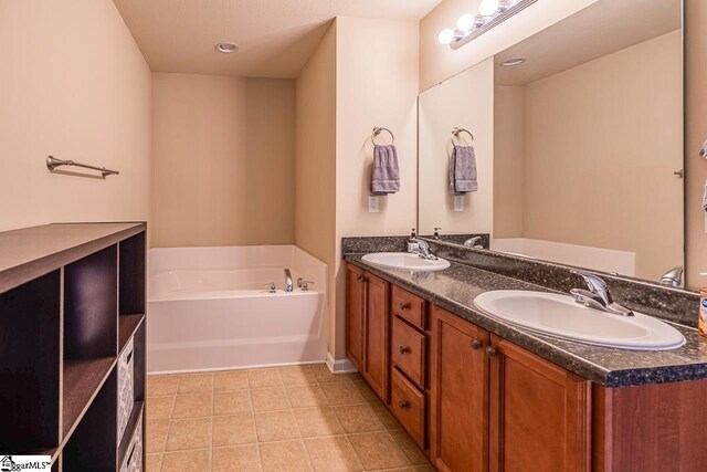 bathroom with a garden tub, a sink, tile patterned floors, and double vanity