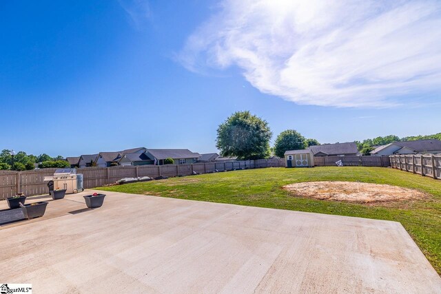 view of patio / terrace with a fenced backyard, an outdoor structure, a shed, and a residential view