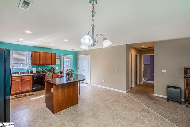 kitchen featuring dark countertops, a sink, brown cabinetry, a kitchen island, and black appliances