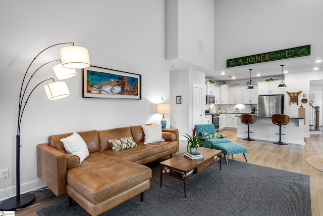 living area with light wood-type flooring, recessed lighting, baseboards, and visible vents
