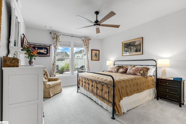 bedroom with a ceiling fan, baseboards, visible vents, and light carpet