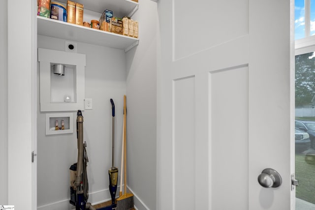 laundry area featuring baseboards, hookup for a washing machine, electric dryer hookup, and laundry area